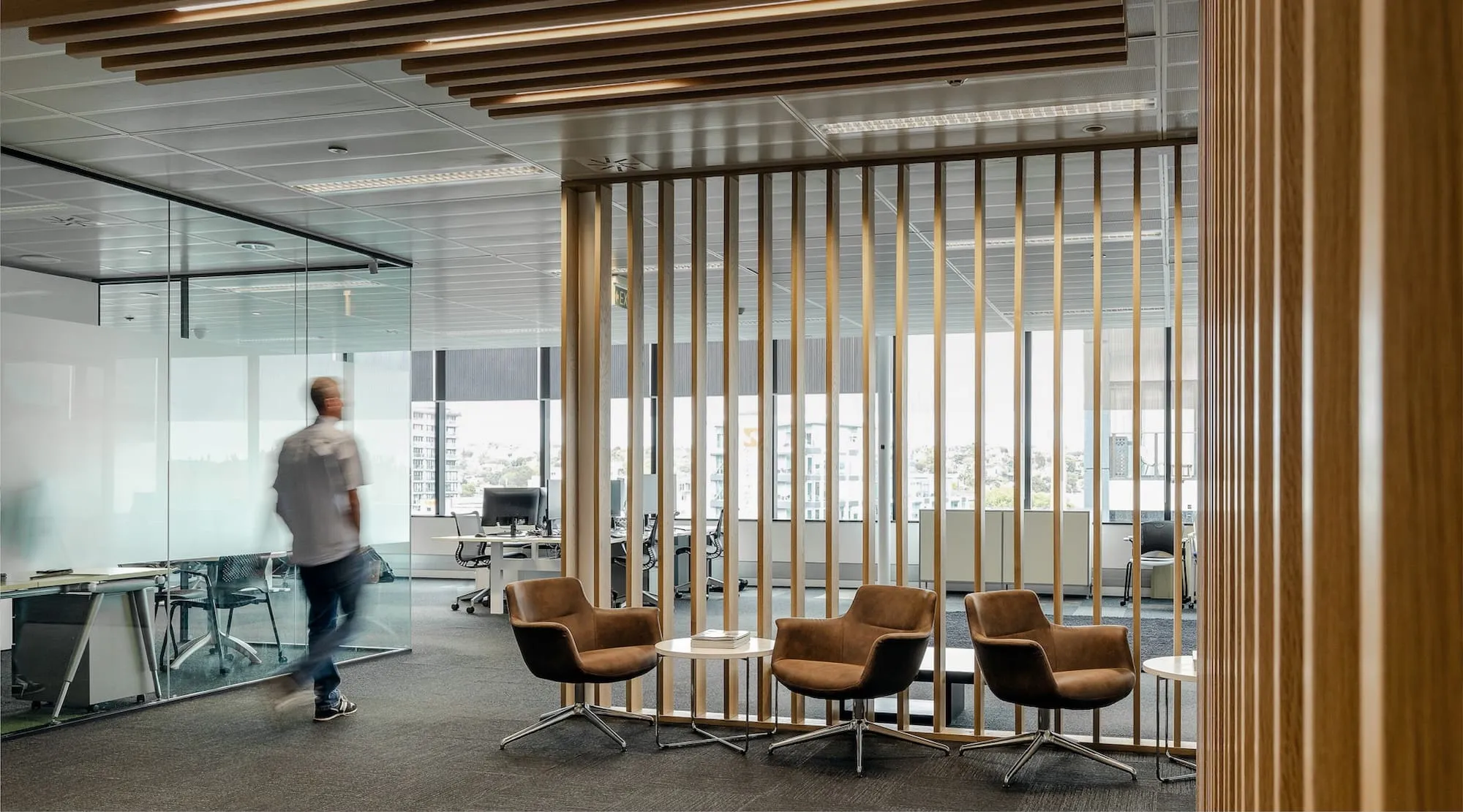 A completed enteria office fit out in Auckland, with open workstations, glazing and timber screening